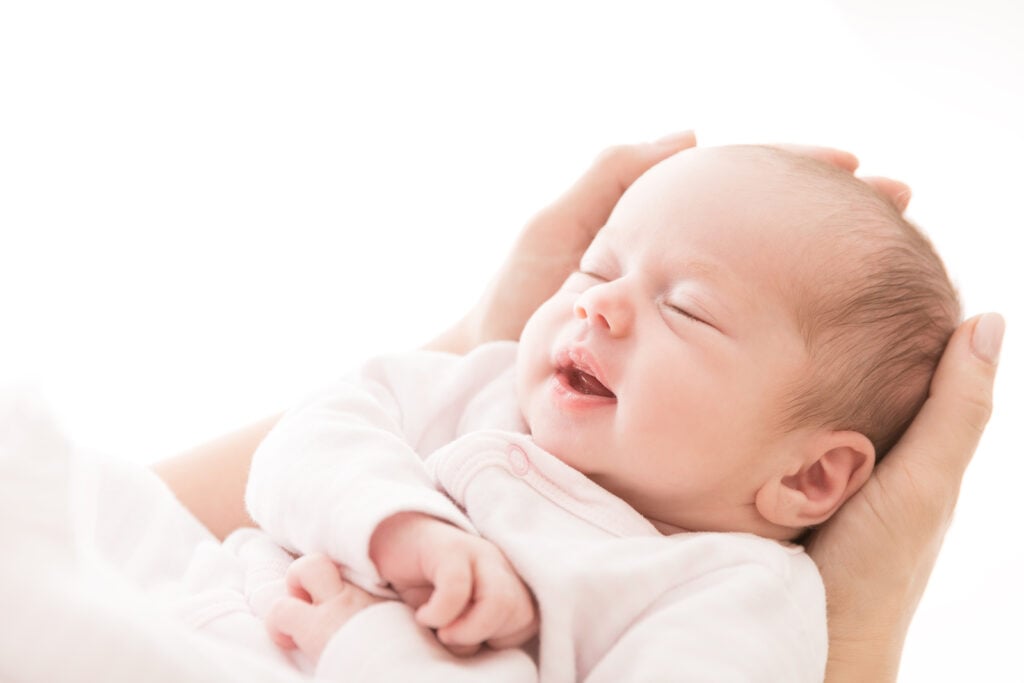 newborn baby sleeping in parents hands I The Peaceful Sleeper