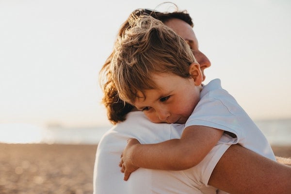 a mother holding her baby after talking about body safety boundaries | The Peaceful Sleeper 