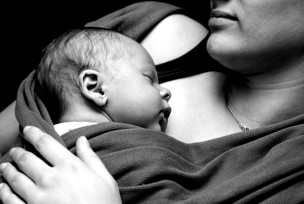 Grayscale photo of baby sleeping very close to mother. You do not have to sleep train alone! You can outsource help from a sleep training professional. The Peaceful Sleeper Blog