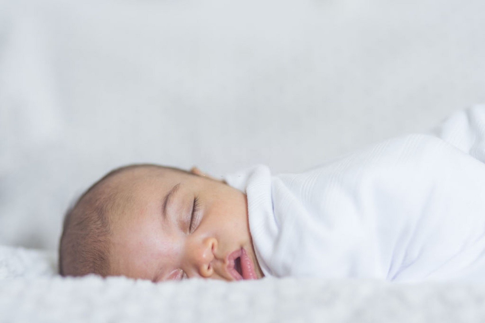 newborn sleeping on a blanket after parents read a newborn sleep guide | The Peaceful Sleeper