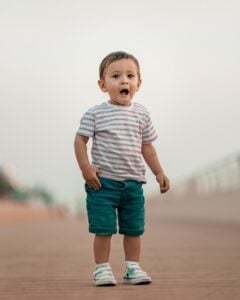 24 month old boy standing in a striped shirt | The Peaceful Sleeper 