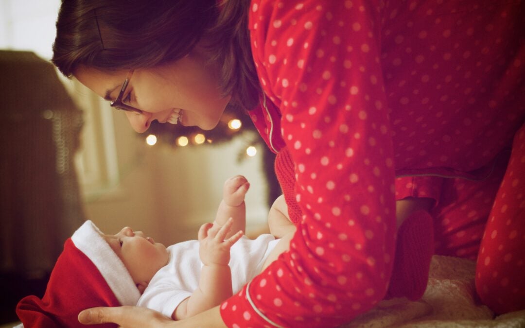 a mother putting her newborn to sleep during the holidays | The Peaceful Sleeper