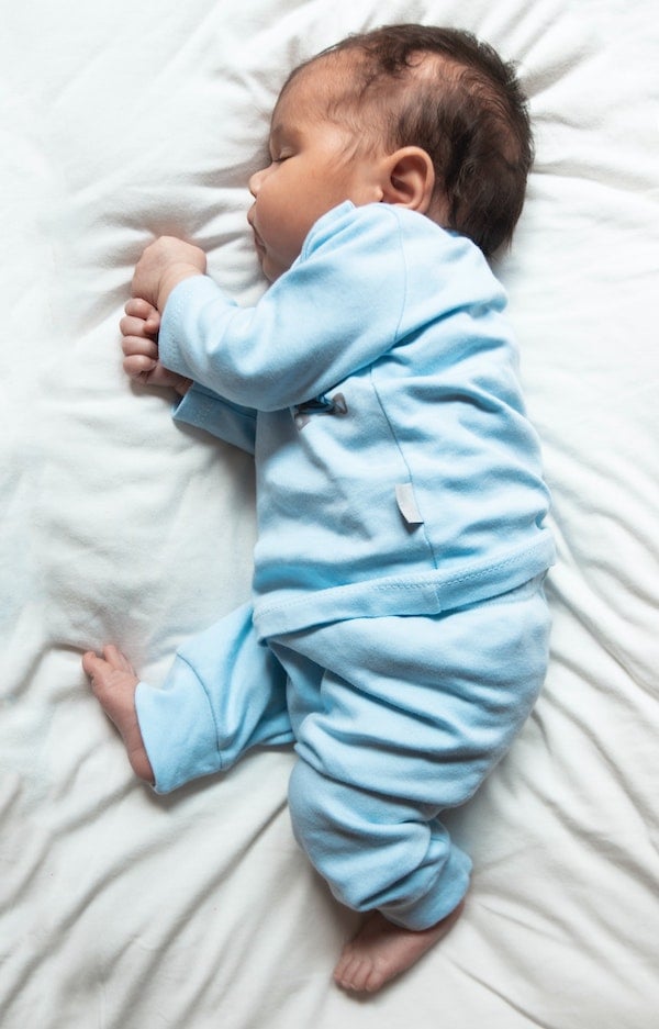 newborn baby in blue pajamas taking a nap | The Peaceful Sleeper