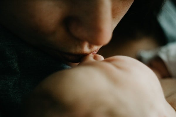 mother kissing a newborn baby | The Peaceful Sleeper 