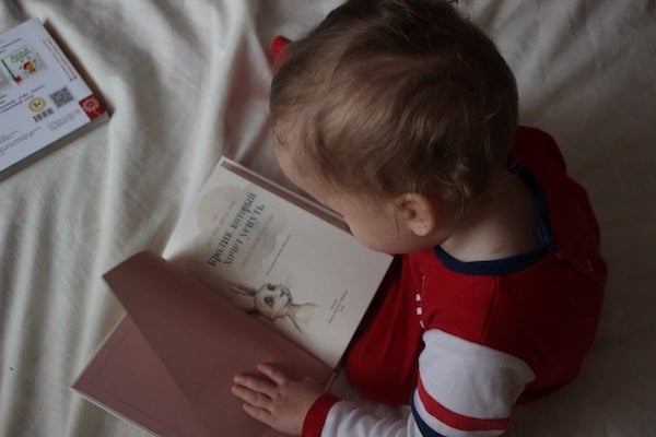 toddler reading a book before going to bed | The Peaceful Sleeper 
