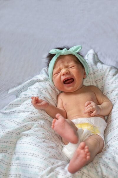 Overtired baby crying on a blanket |The Peaceful Sleeper