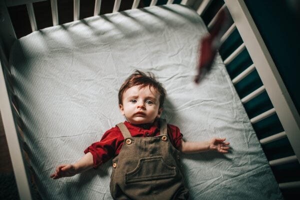 a baby laying in his crib having poor nighttime sleep | The Peaceful Sleeper