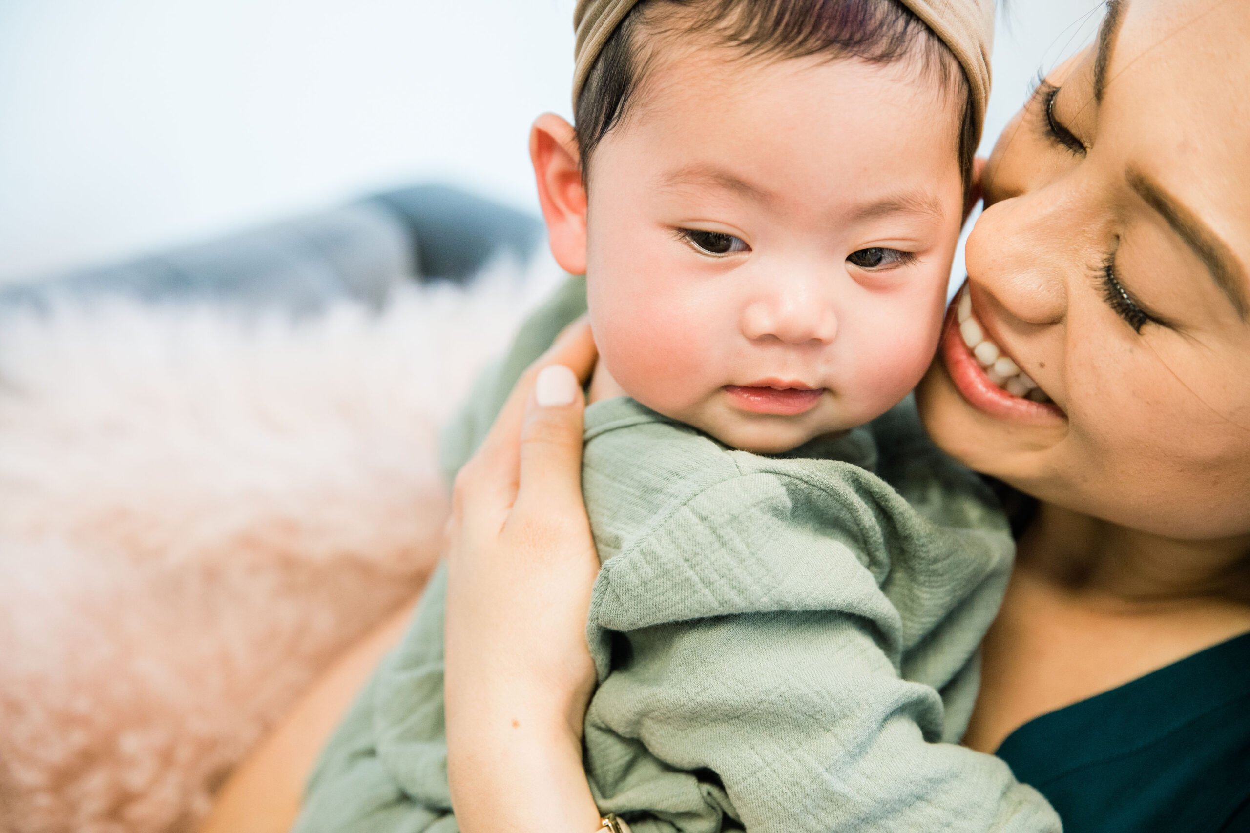 mother holding her baby while smiling | The Peaceful Sleeper