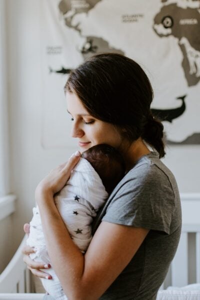 mom with swaddled baby | The Peaceful Sleeper