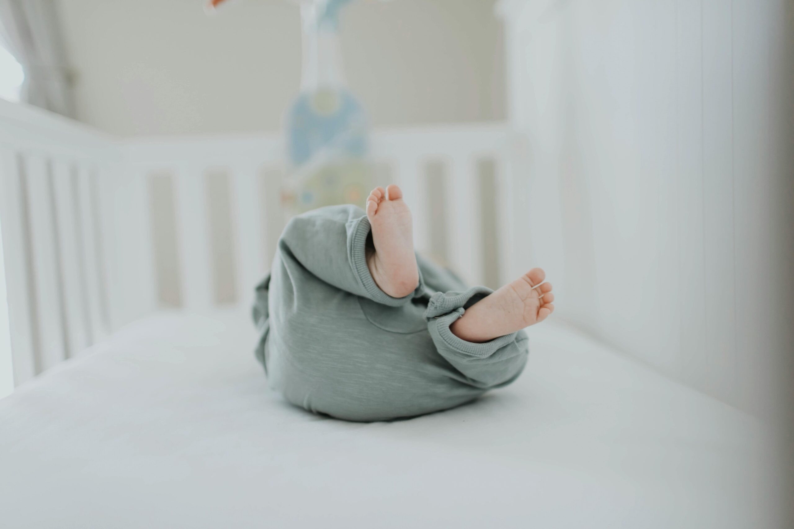 Baby in Crib - When Can You Start Sleep Training Blog | The Peaceful Sleeper