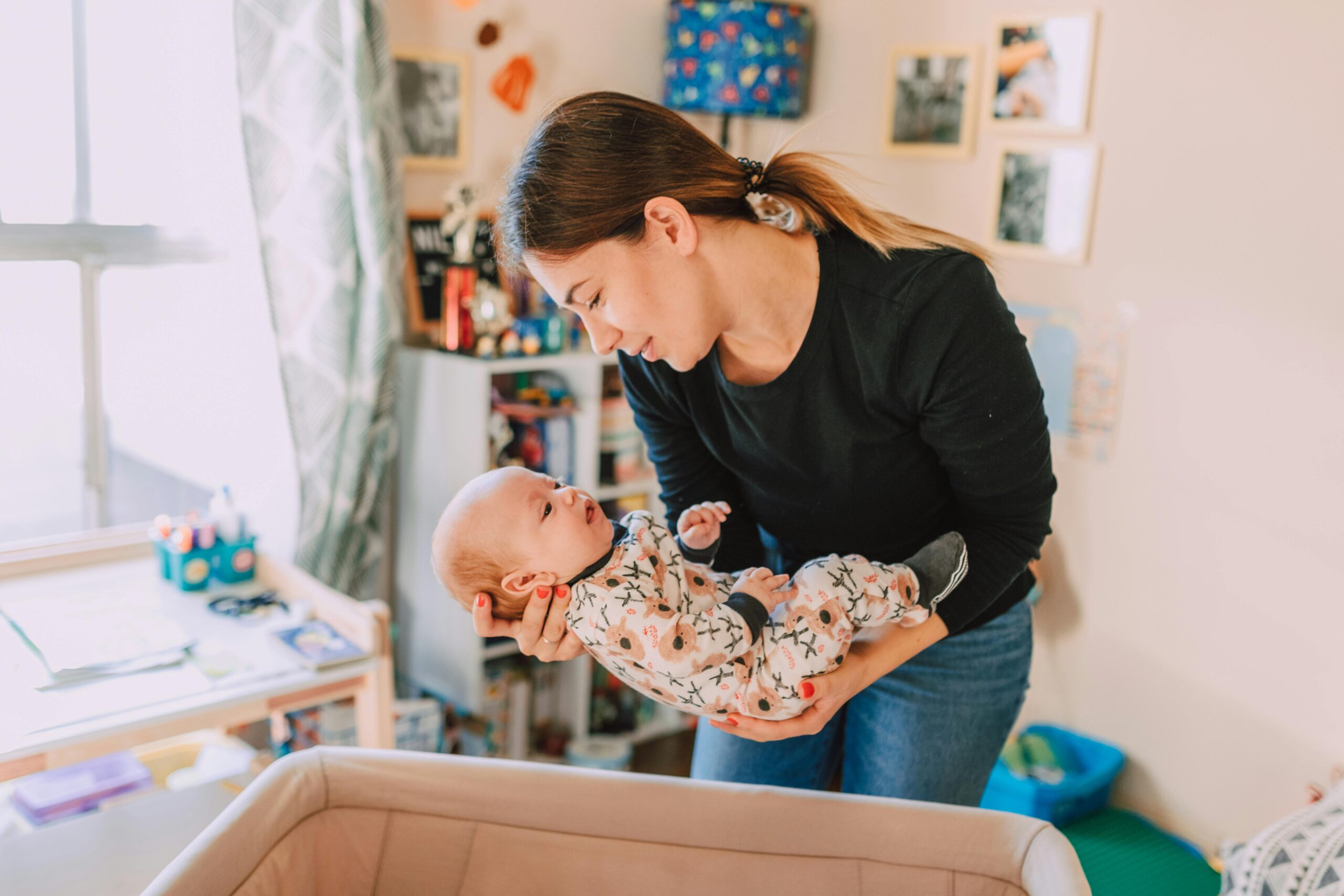 Mom Putting Baby in Bassinet | The Peaceful Sleeper