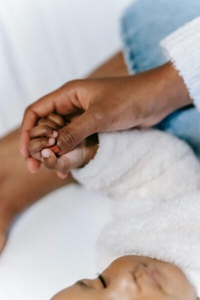 Mom Holding Baby's Hand | The Peaceful Sleeper